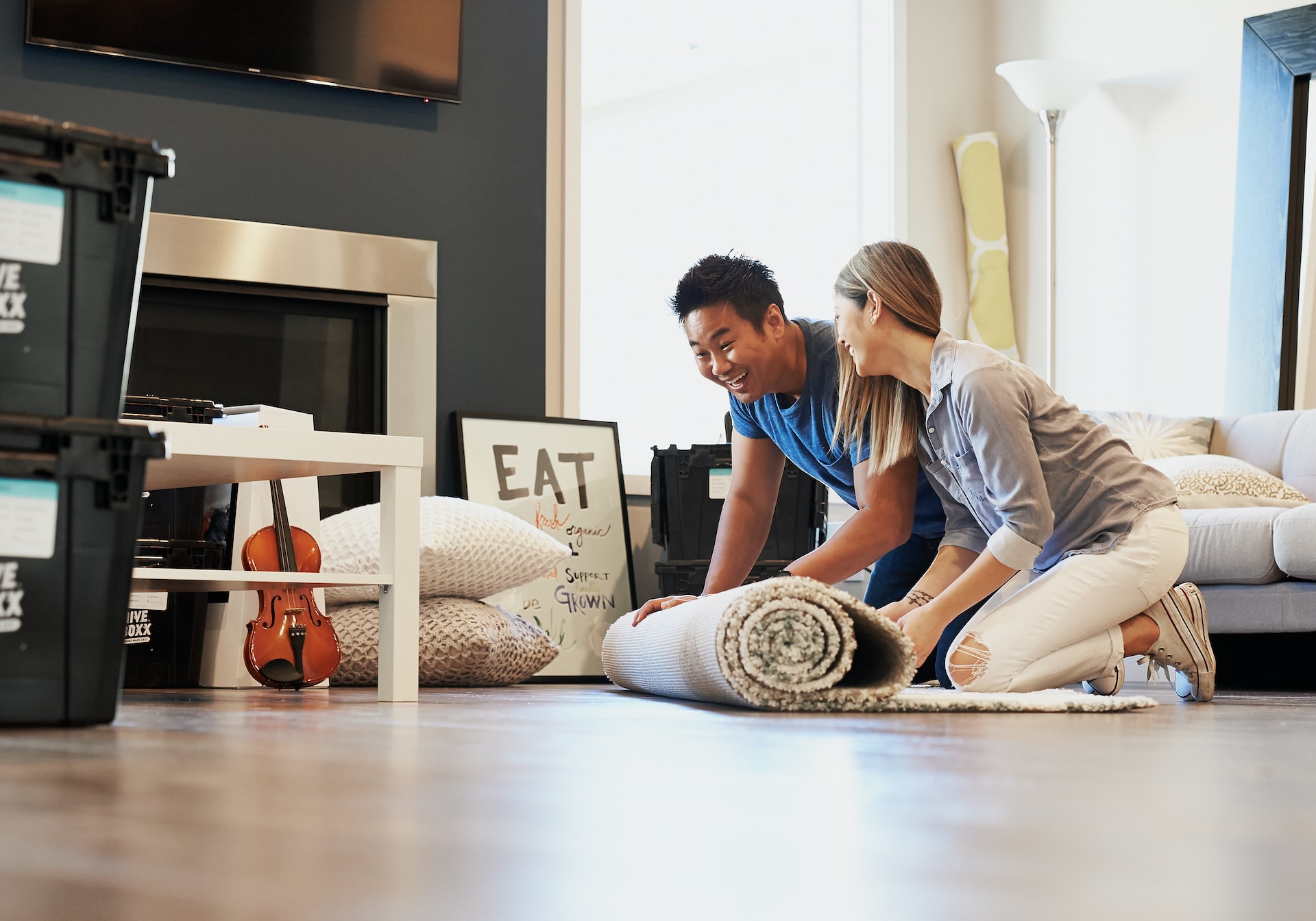 couple rolling out carpet on floor