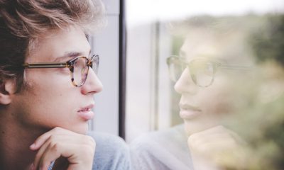 guy looking at own reflection through the window glass