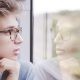 guy looking at own reflection through the window glass