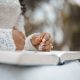 Crop bride holding ring and reading wedding vow