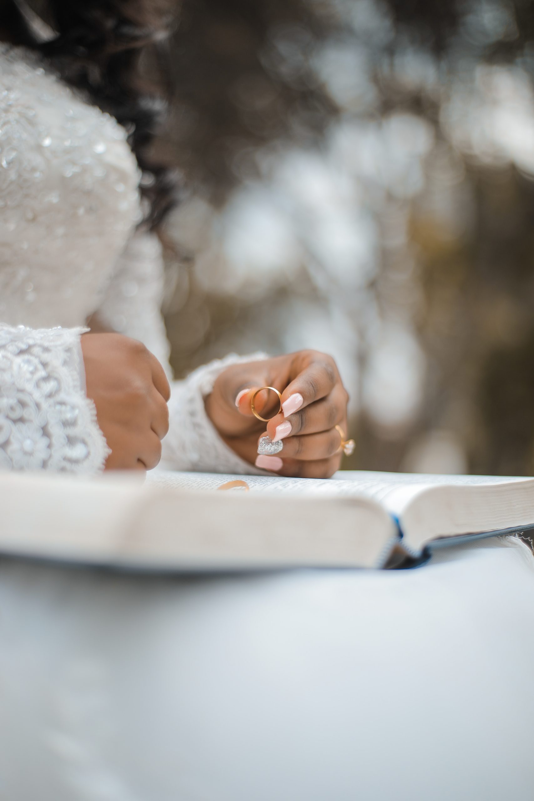 Crop bride holding ring and reading wedding vow