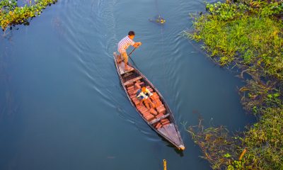 Two Person Riding Black Wooden Boats