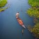 Two Person Riding Black Wooden Boats