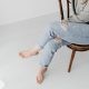 Person Wearing Ripped Jeans Sitting on a Wooden Chair