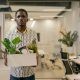 A Man Carrying White Box with Green Plant and Things in it