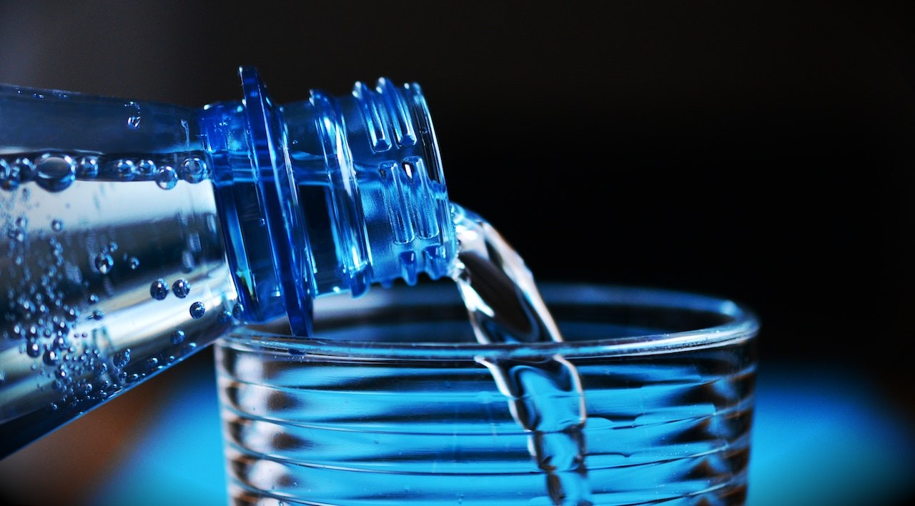 bottled water poured on a glass