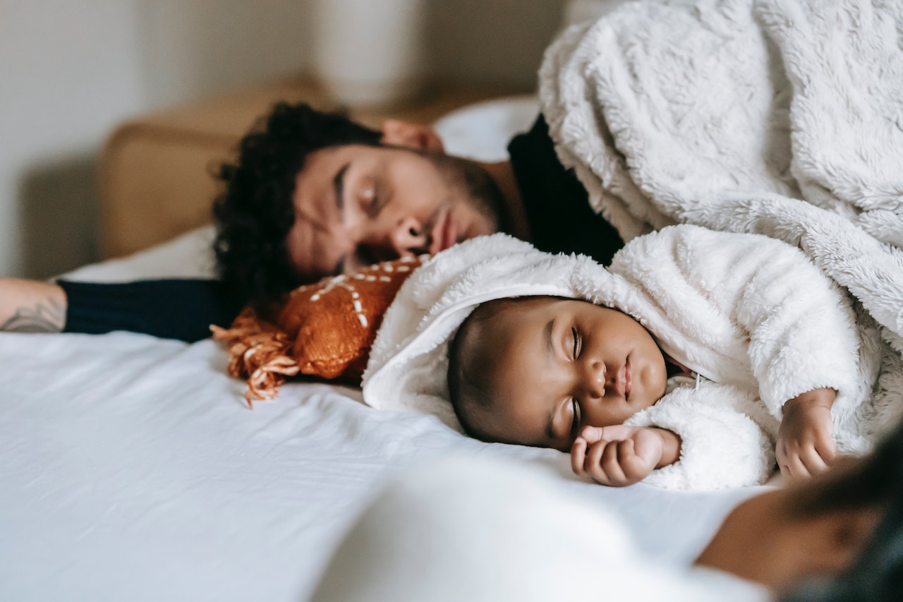 father and son sleeping on bed