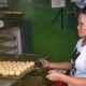 woman taking out a tray of pandesal from the oven