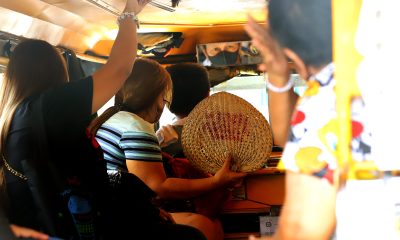 woman fanning with abaniko inside a jeepney