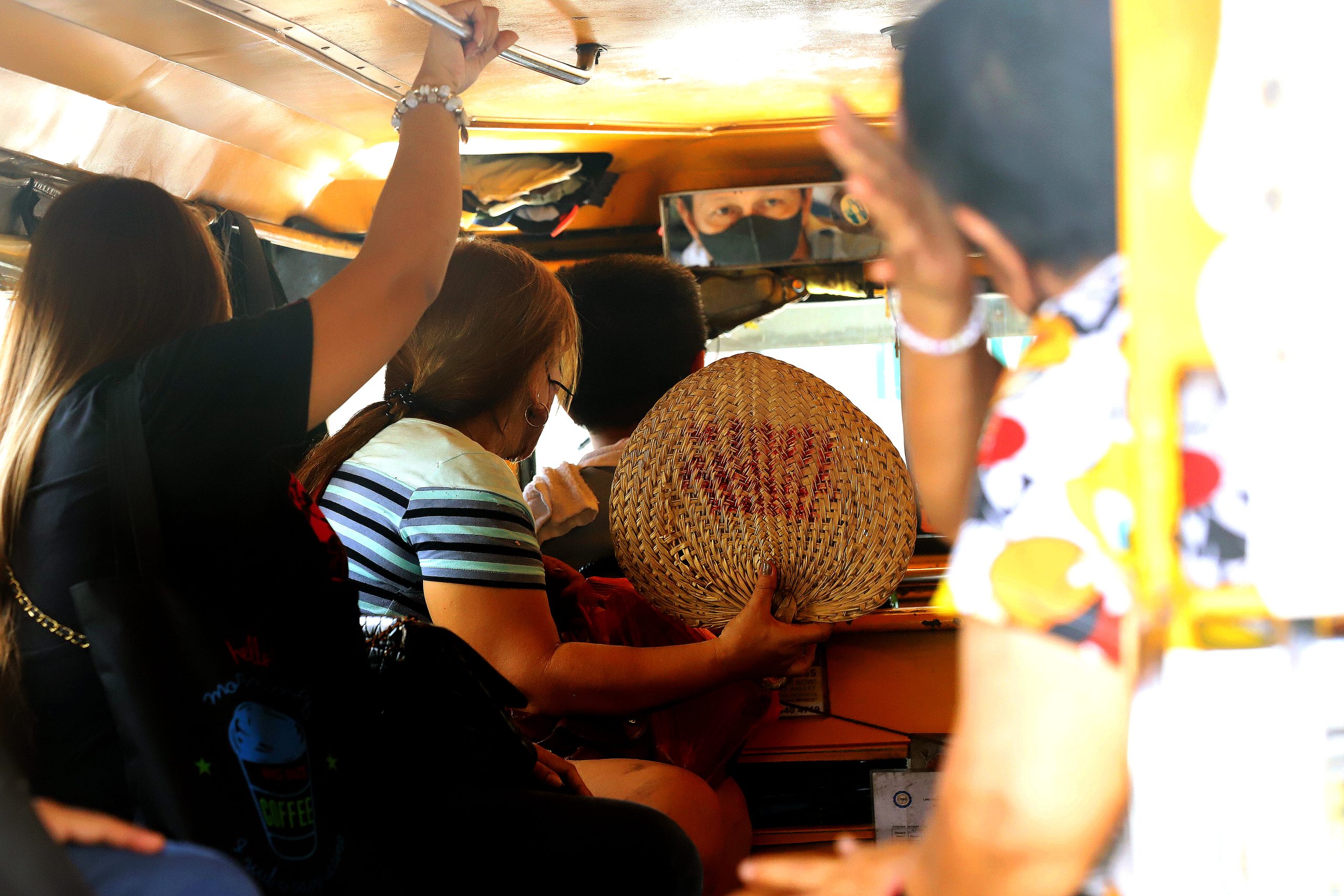 woman fanning with abaniko inside a jeepney