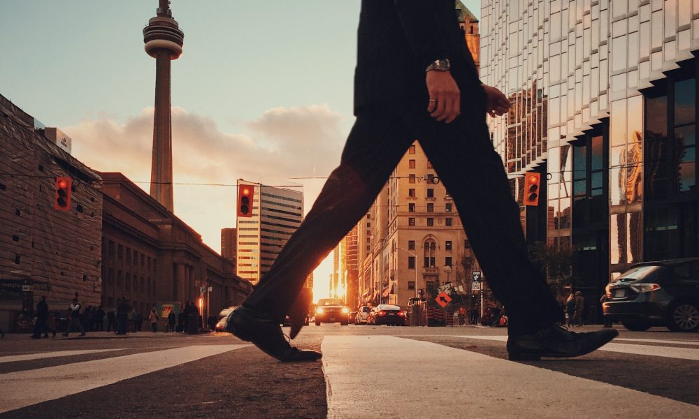 legs crossing street with canada buildings