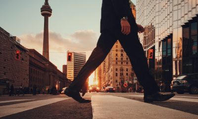 legs crossing street with canada buildings