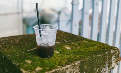 half-filled plastic cup with straw