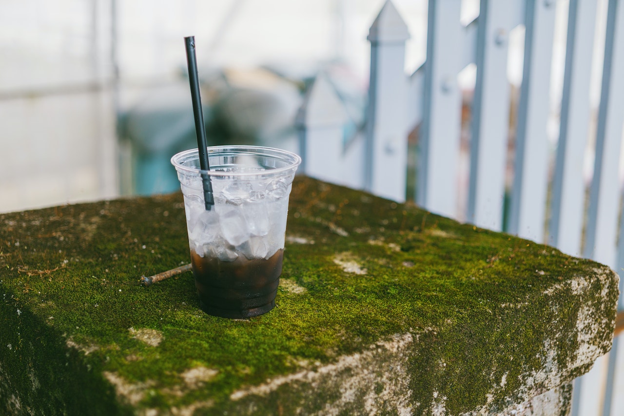 half-filled plastic cup with straw