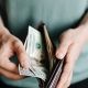 man taking out dollar bills from wallet