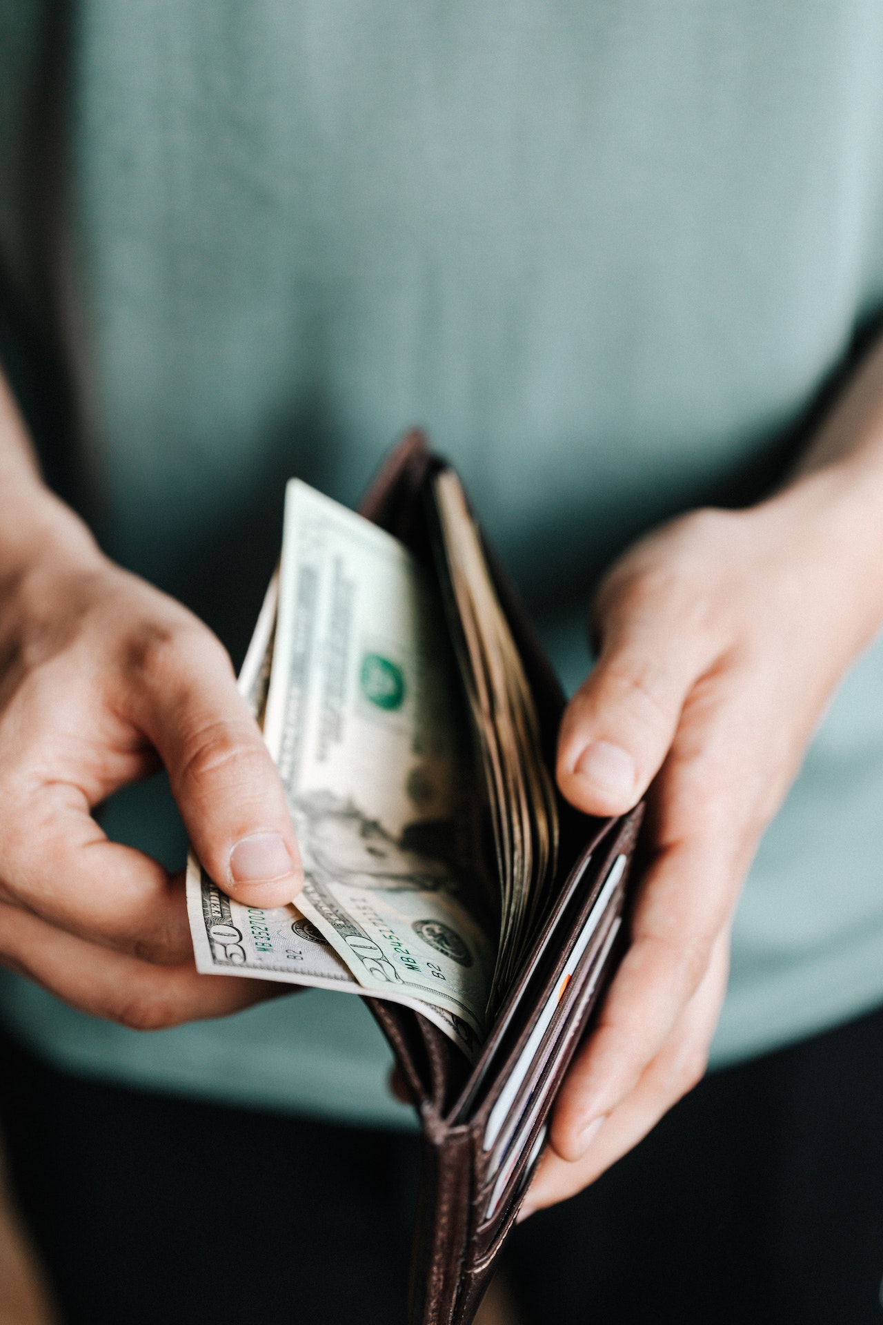 man taking out dollar bills from wallet