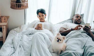 man and woman on bed with dog