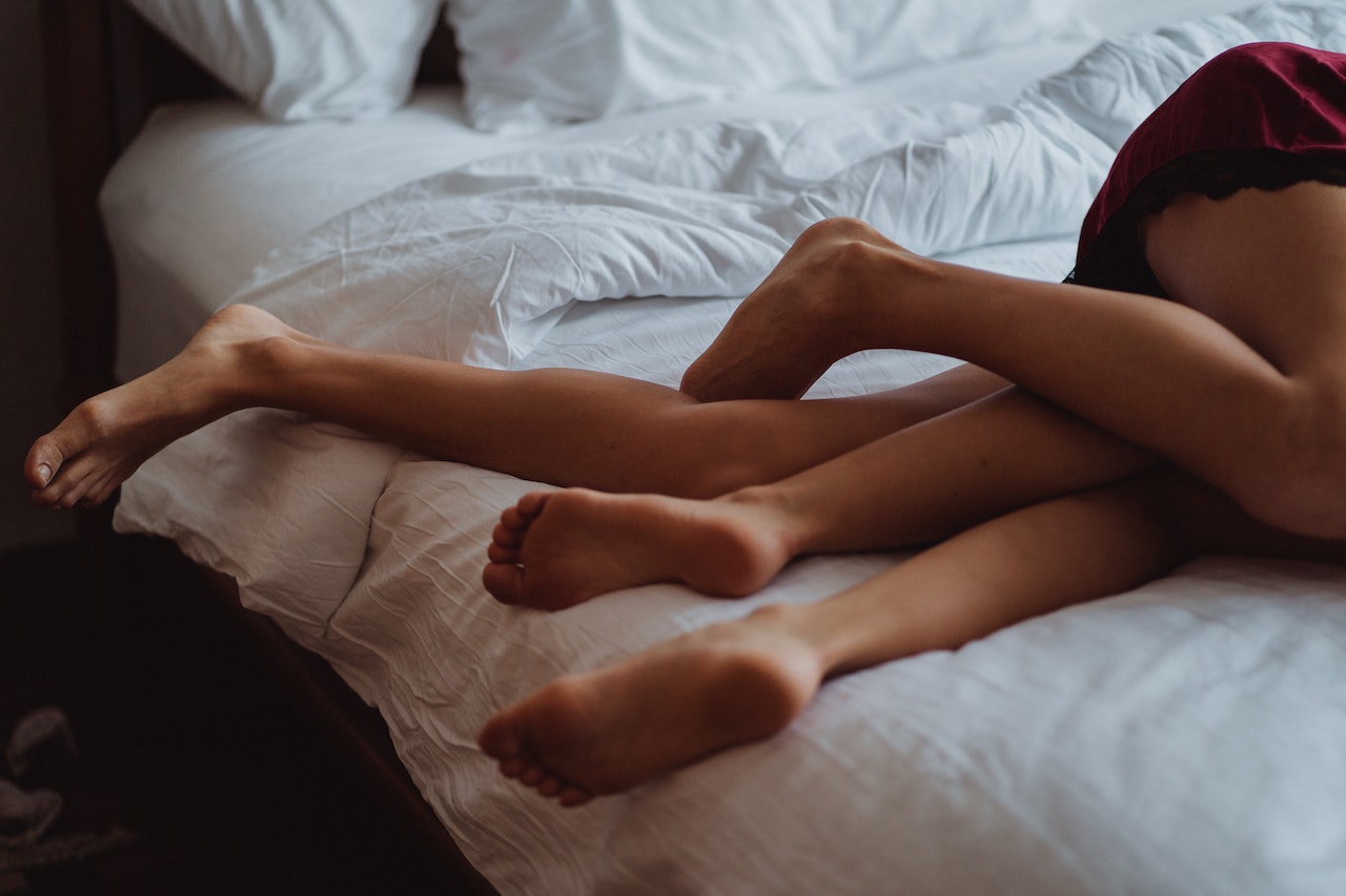 legs of couple on bed