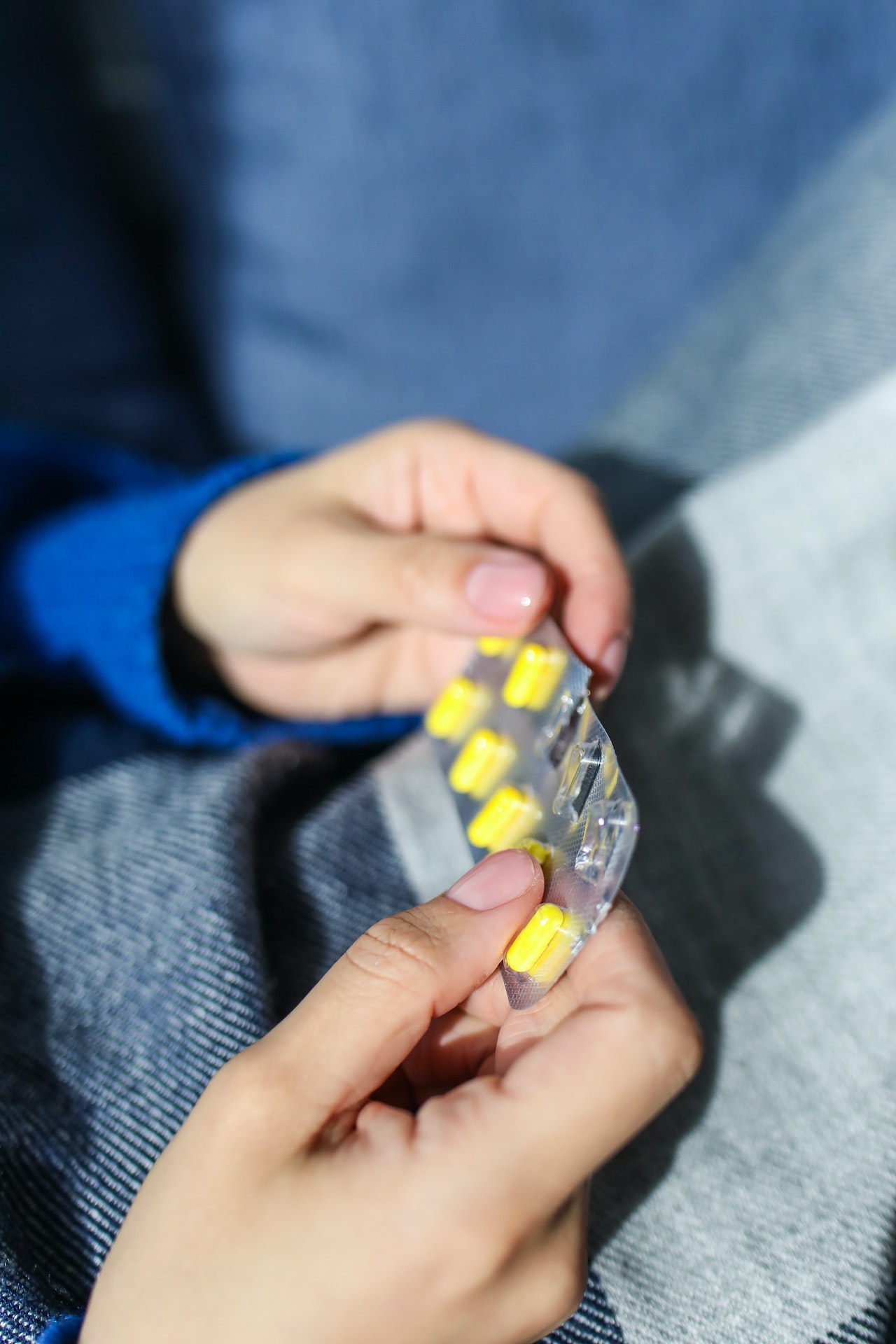 hands holding yellow pills