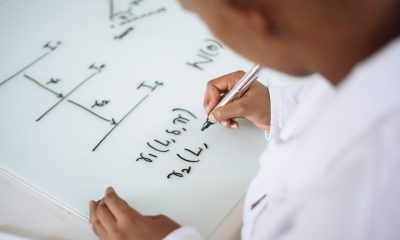 person solving math on white board
