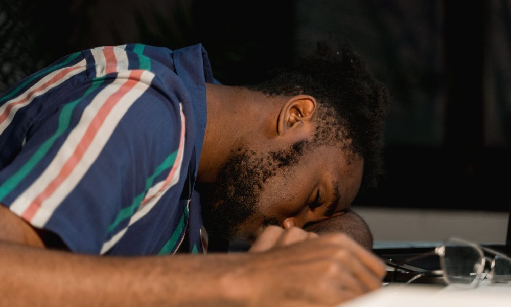 Close Up Photo of Man Sleeping on Desk