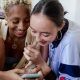 two women smiling while looking at phone screen