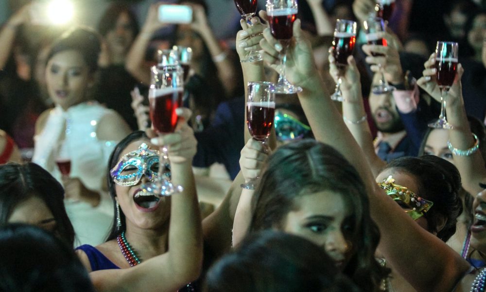 women wearing masks while raising glasses in a party