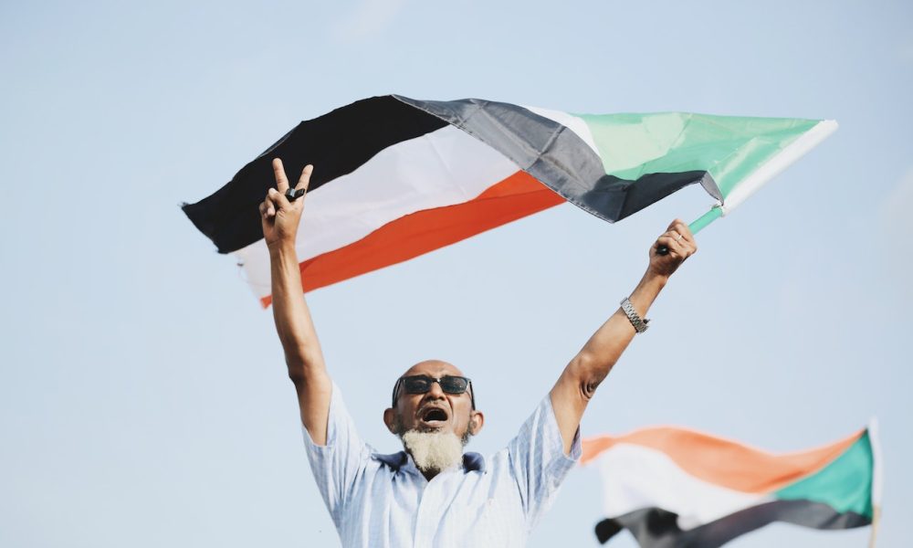 man waving sudanese flag