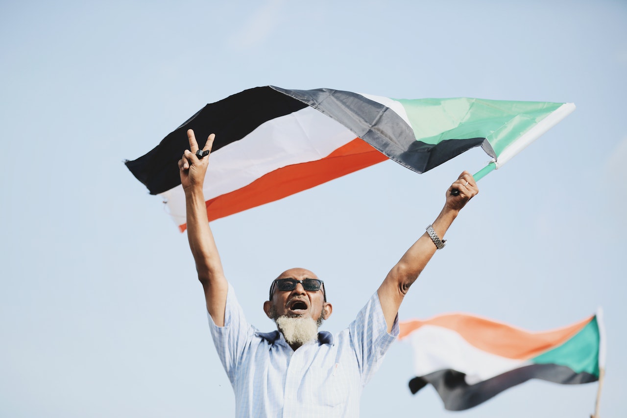 man waving sudanese flag