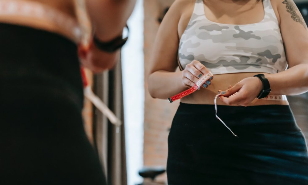 woman measuring waist with tape