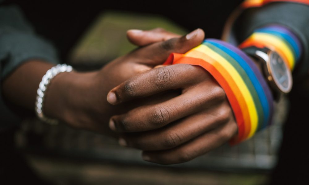 hands wearing lgbt flag ribbon