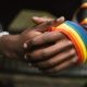 hands wearing lgbt flag ribbon