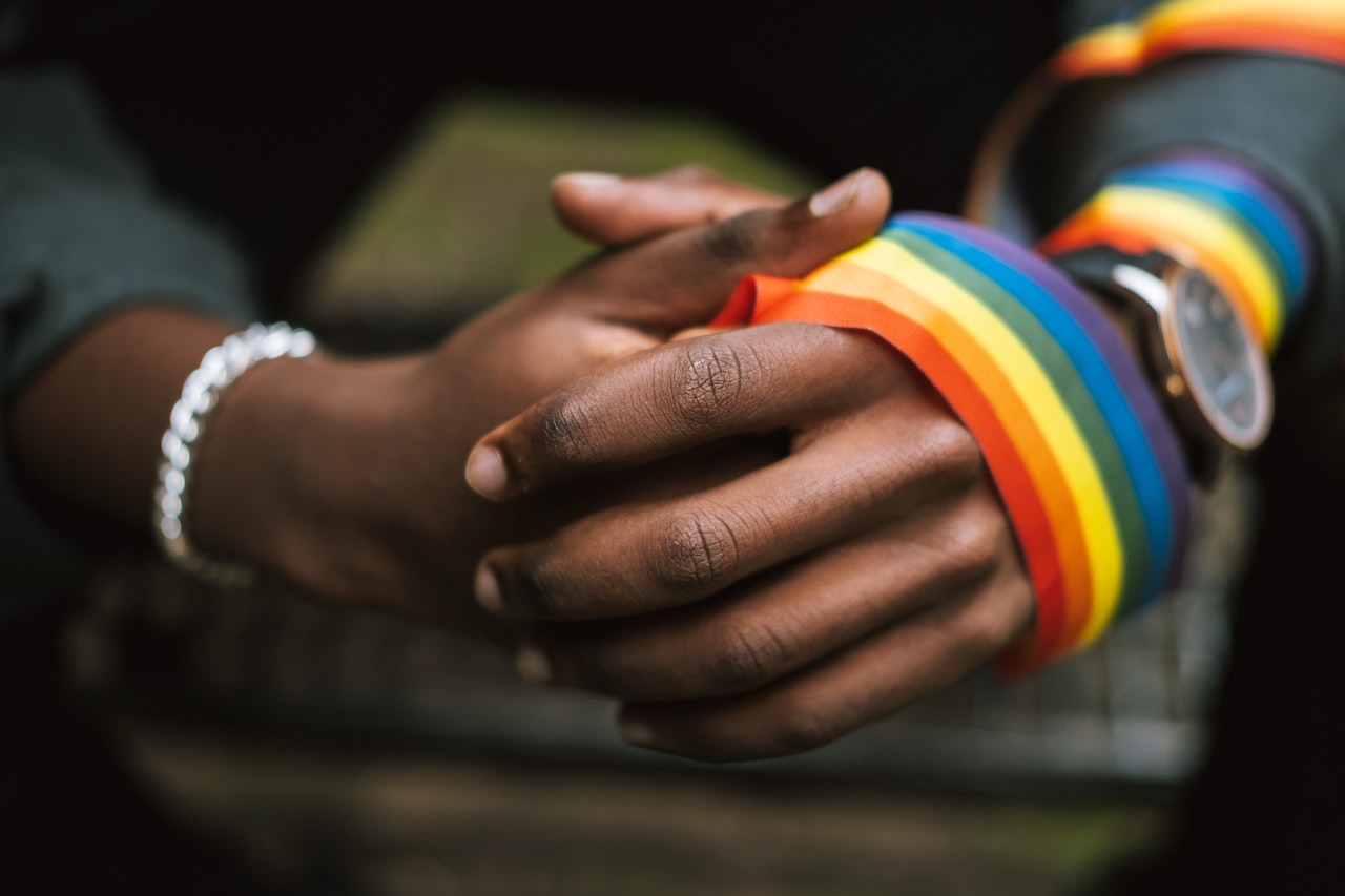 hands wearing lgbt flag ribbon