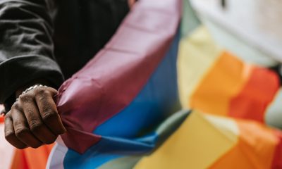 hand holding an lgbtiq+ flag