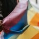 hand holding an lgbtiq+ flag