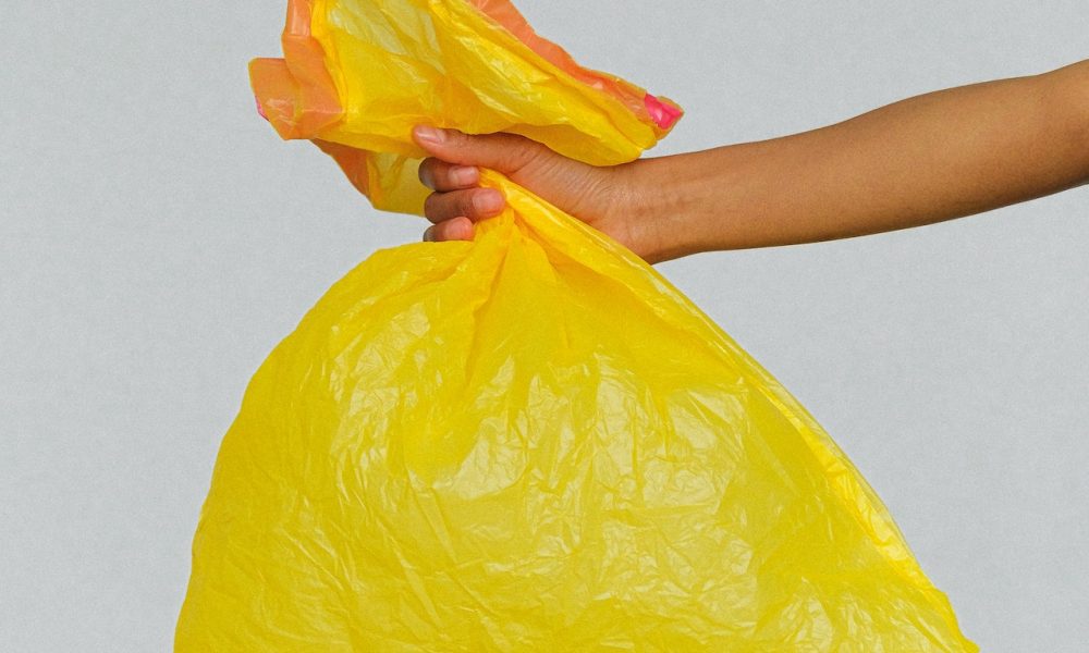 hand holding yellow plastic bag