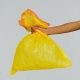 hand holding yellow plastic bag