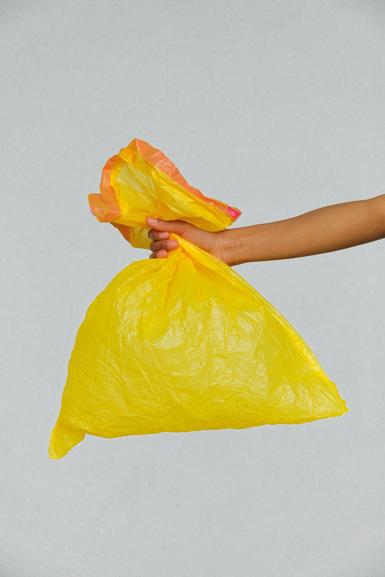 hand holding yellow plastic bag