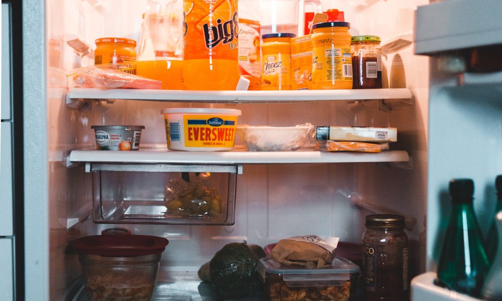 Opened fridge with drinks and food