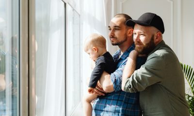 A Couple Looking Out the Window with Their Baby