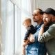 A Couple Looking Out the Window with Their Baby