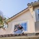 man installing solar panel on roof