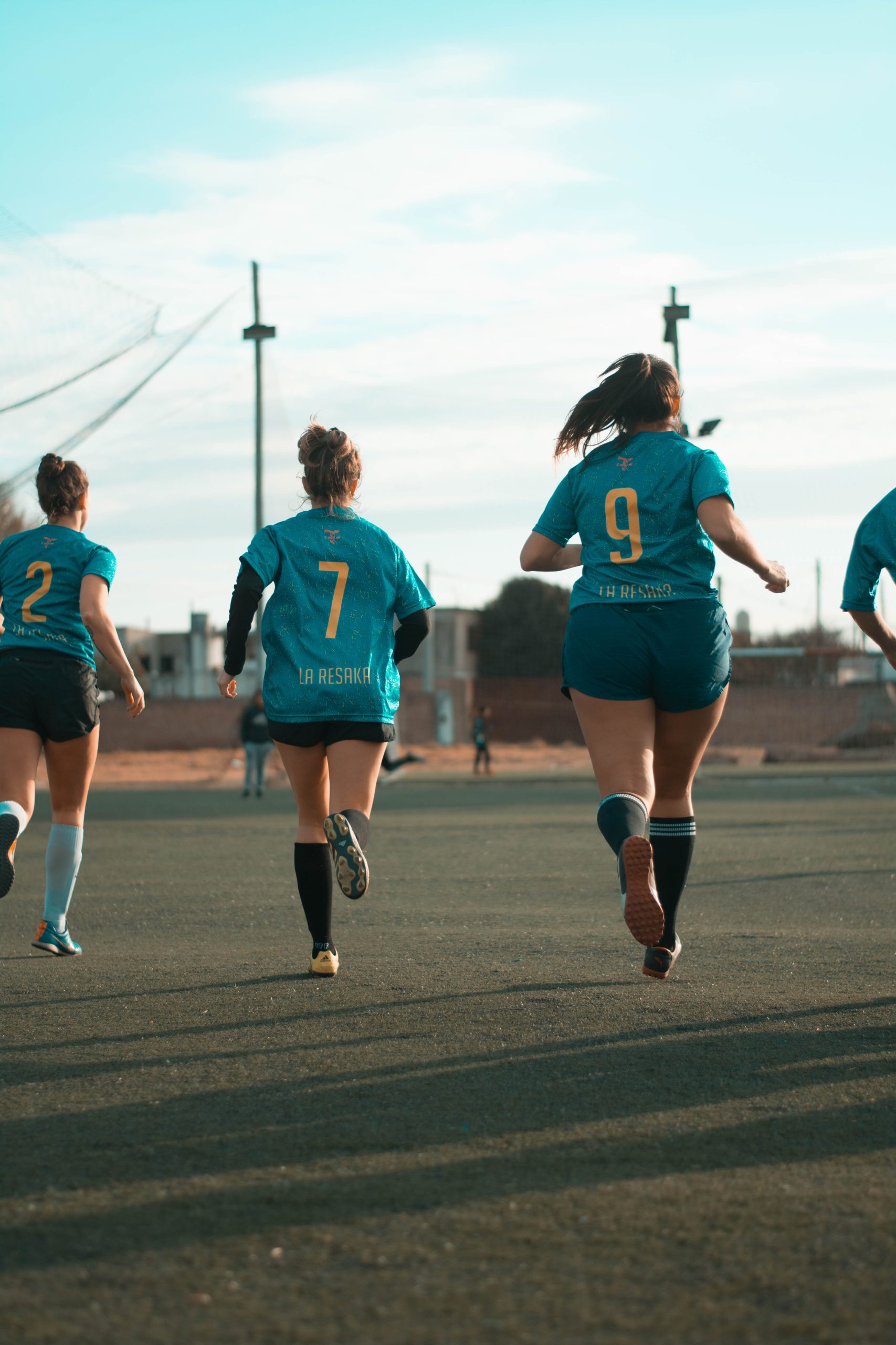 Three Women Wearing Blue Jersey Shirt Running