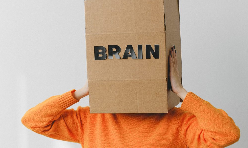 Box with Brain title on head of unrecognizable woman