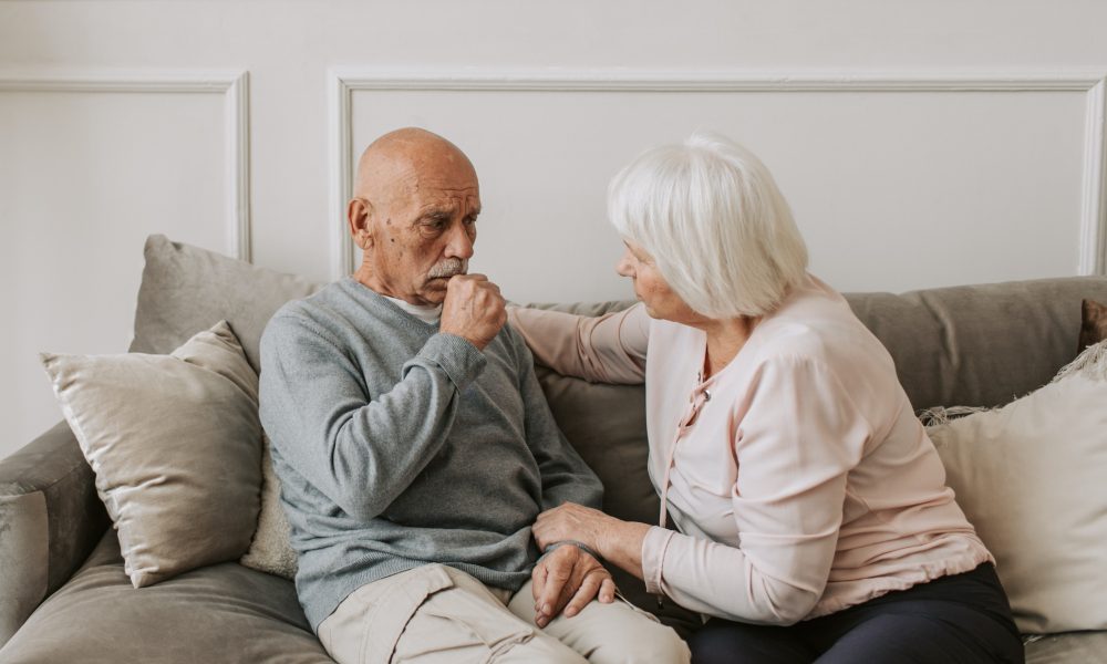 Man in Gray Sweater Sitting Beside Woman