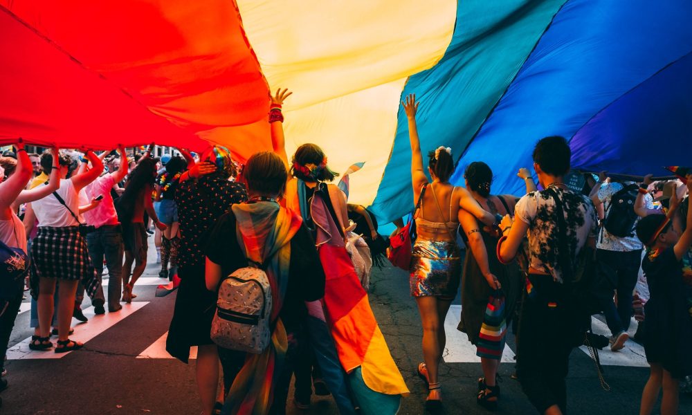 people under a huge pride flag