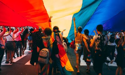 people under a huge pride flag