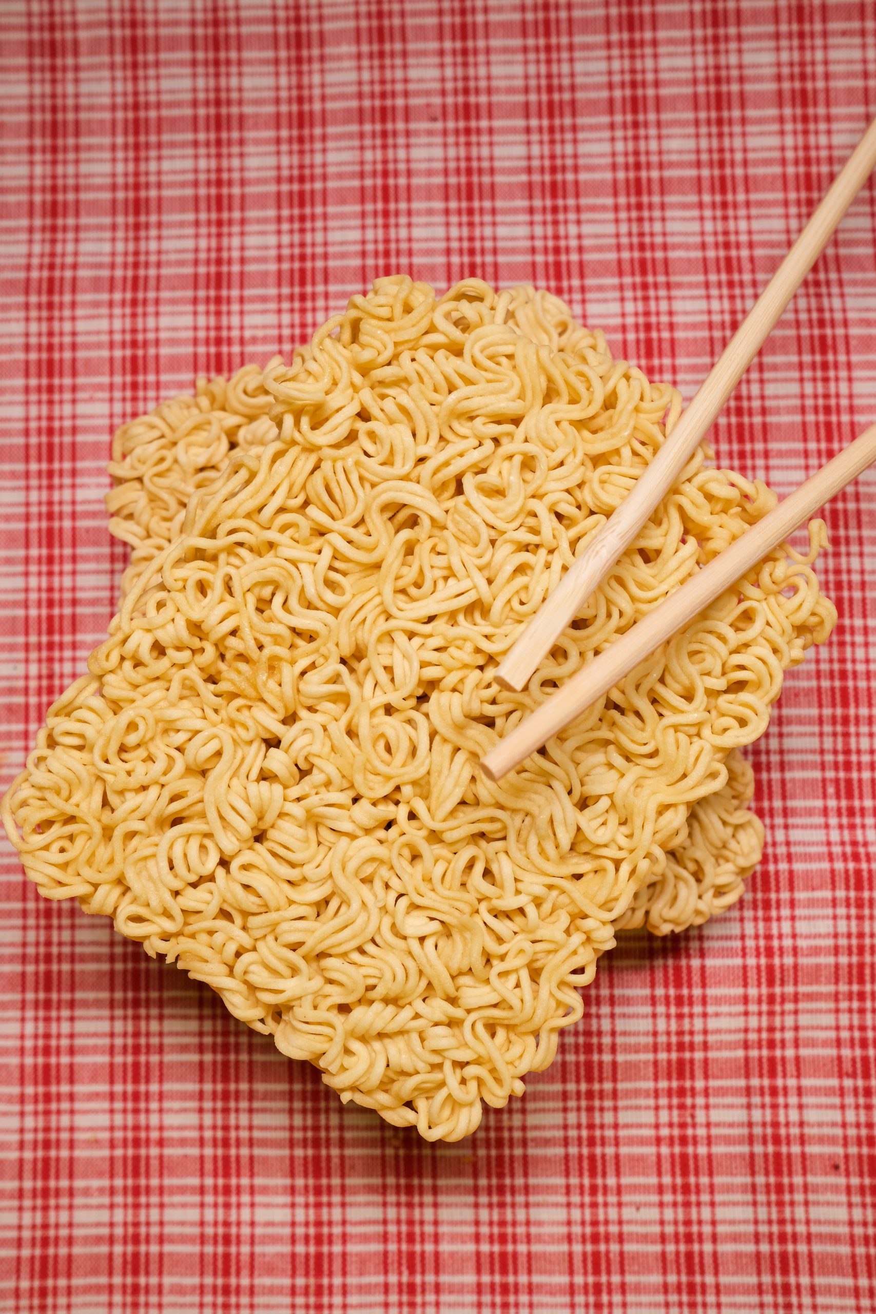 Oriental dried noodles and chopsticks placed on table