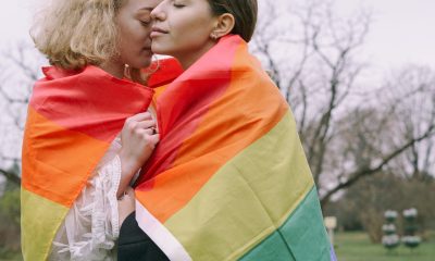 LGBT flag wrapped around sweet couple