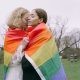 LGBT flag wrapped around sweet couple